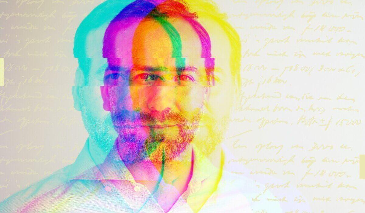 A man stands against a vibrant, colorful background.