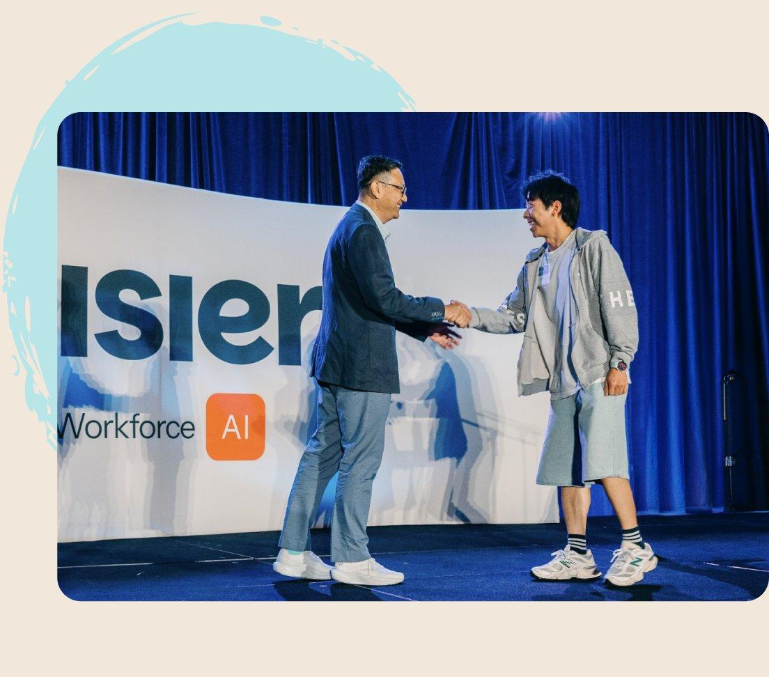 Two Visier leaders shaking hands on stage at a company event